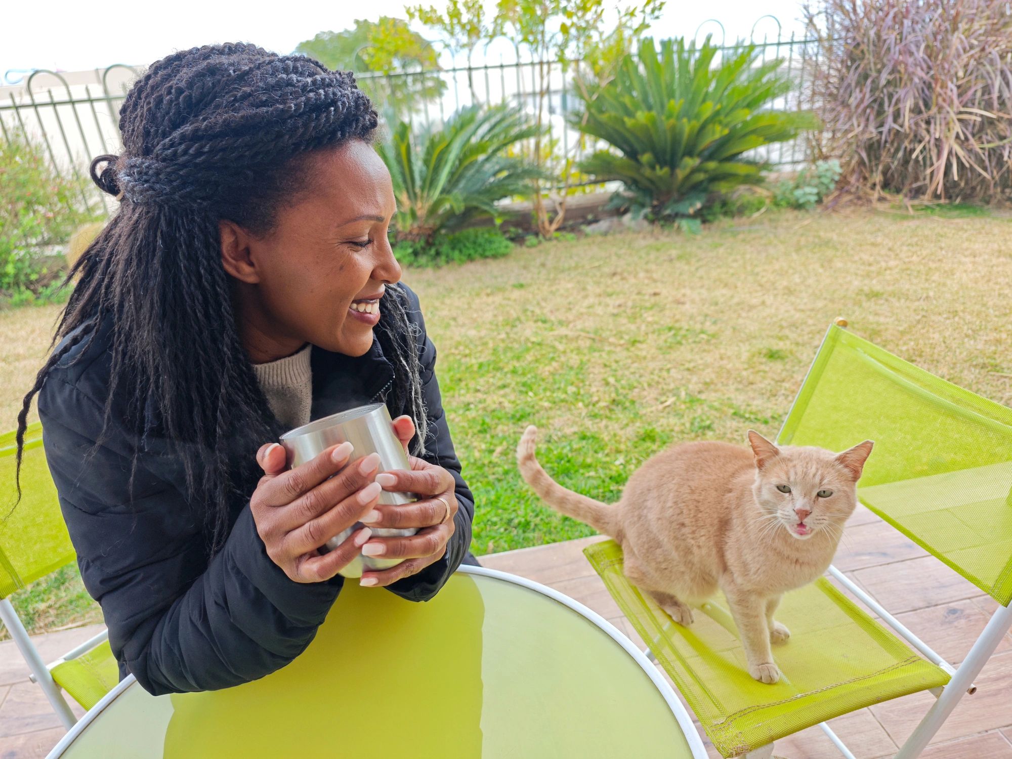Pet owner spending time with a ginger cat outdoors